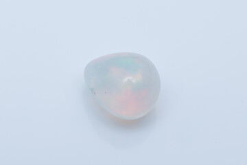 Glowing White Opal Gemstone with Rainbow Play of Color on White Background