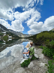 Couple, man and woman, sitting on a stone and looking to the mountains. Mountain background. Travel concept. Zakopane, Poland. Hikers in the mountain