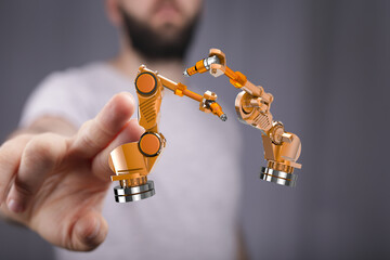 Image of a man interacting with a 3D model of robotic arms, showcasing automation and technology.