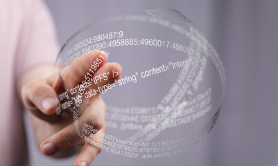 Close-up of a hand interacting with a transparent sphere displaying lines of code, representing...