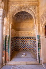 Ornate alcove with colorful tiles and arabic inscriptions in Alhambra, Granada, Spain