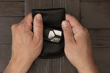 A man wraps his car keys in silver foil, trying to protect his car from theft by a thief,