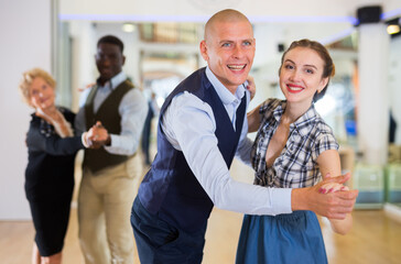 Man and woman dancing waltz in studio