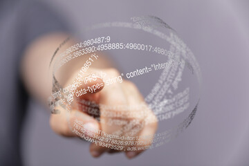 Hand points at a futuristic transparent sphere displaying digital code and data.