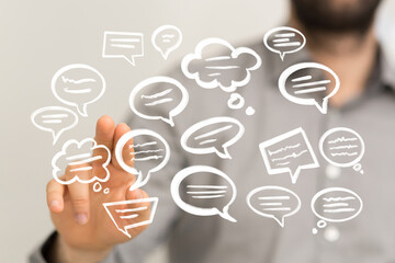 Stock photo of a person interacting with digital speech bubbles, representing communication,...
