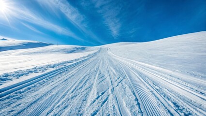 Snow-Covered Ski Tracks Leading Upward on a Bright Winter Day Against a Blue Sky
