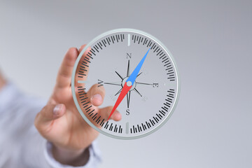 Hand interacts with a virtual compass, symbolizing direction, strategy, and planning.