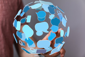 Abstract image of a person interacting with a sphere of speech bubbles, symbolizing global...