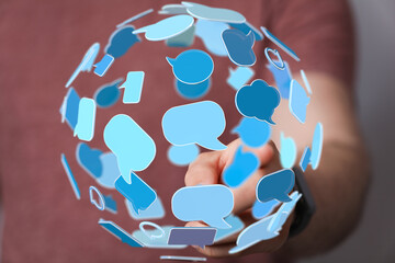 Person interacting with a sphere of digital chat bubbles, representing global communication and...
