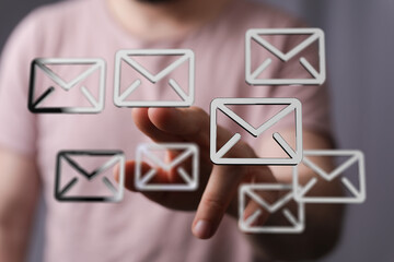Close-up of a person's hand interacting with email icons, representing communication and technology.