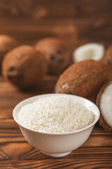 Set of fresh whole and half coconuts and slices on wooden background. Coconut flakes. Vegan. Tropical nut, fruit. Place for text. Copy space.