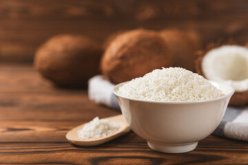 Set of fresh whole and half coconuts and slices on wooden background. Coconut flakes. Vegan....
