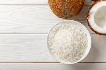 Set of fresh whole and half coconuts and slices on wooden background. Coconut flakes. Vegan....