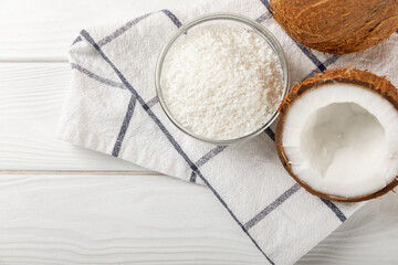 Set of fresh whole and half coconuts and slices on wooden background. Coconut flakes. Vegan. Tropical nut, fruit. Place for text. Copy space.