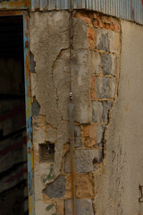 This is a detailed closeup view of a brick wall that features areas of peeling paint, showcasing various textures and colors of the materials