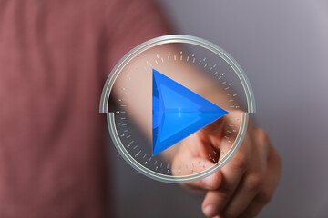 Close-up of hand interacting with a digital play button interface.  Modern technology concept.