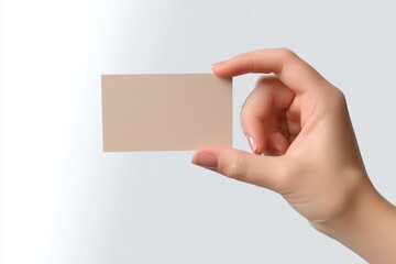 Obraz premium Hand Holding a Blank Business Card Against a Light Background