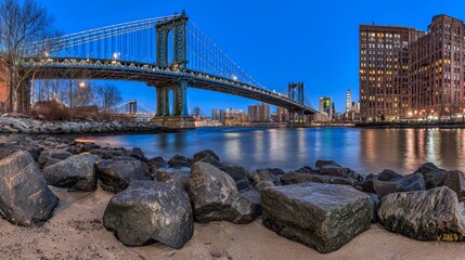 Suspension bridge at dusk illuminated by warm city lights, showcasing an urban landscape.