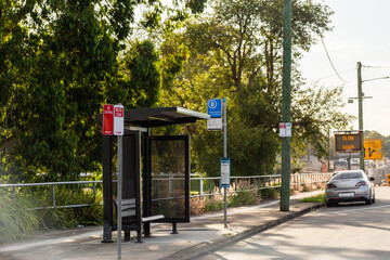Bus stop shelter beside city road with no stopping sign and roadworks slow down signage