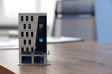 House model on desk in real estate agent's office, space for text