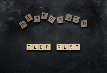 Wooden letter tiles spelling 'deep rest' on a dark distressed background