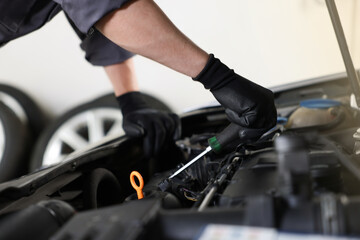 Auto parts. Professional mechanic with screwdriver fixing car indoors, closeup