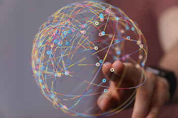 Abstract image of a hand interacting with a colorful data sphere, representing global network...