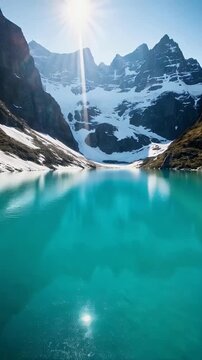 Glacial Lake with Turquoise Water and Snowy Mountain Peaks at Sunrise