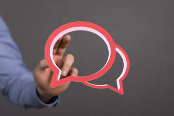 Abstract image of a hand interacting with digital speech bubbles, representing communication and...