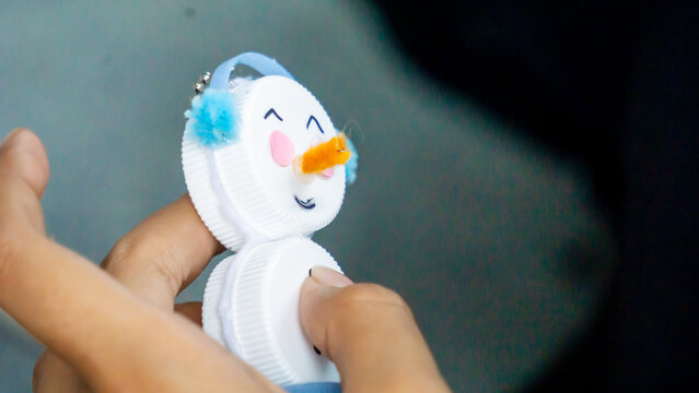 Making key chains from bottle caps and flannel. Recycling plastic materials.