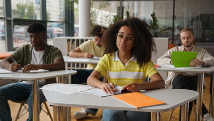 Class lesson in school university college lecture classmates sitting in classroom African American...