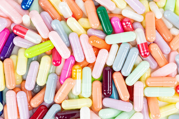 A vibrant, colorful background of assorted pills and medicine capsules. This texture represents the pharmacy industry, healthcare supplements, and the wide array of available treatments.