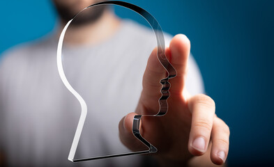 Abstract image of a person interacting with a digital head profile.  Represents AI, technology, or...