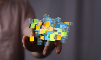 Abstract image of colorful 3D cubes floating above a hand, representing data, technology, or...