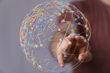 Abstract image of a hand interacting with a colorful, interconnected global network. Represents...