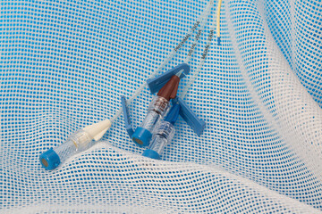 Triple lumen short-term central venous catheter with three infusion channels reflected on blue...