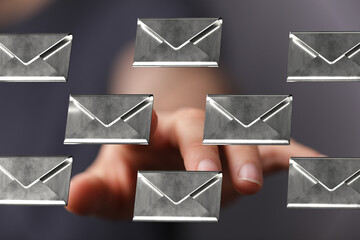 Person interacts with digital email icons.  Concept for communication, inbox, online messaging.