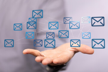 Hand holding digital email icons, representing global communication and networking.