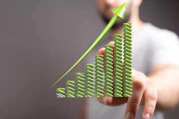 Green arrow pointing up on a bar graph.  Represents growth, success, and financial increase.