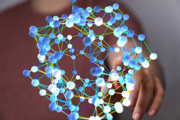 Hand interacting with a 3D network, representing connection, data, and technology.