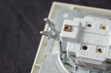 back side of electrical wall switch with visible wiring contacts and metal mounting frame, detailed...