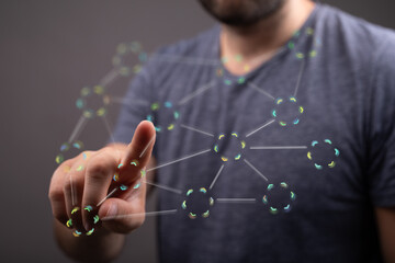A man's finger interacts with a holographic network, showcasing connectivity and technology.