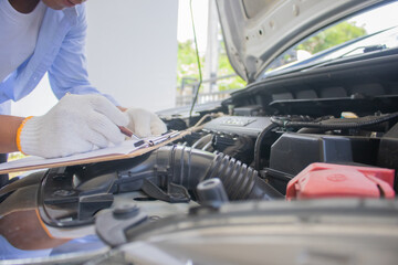 Technician in uniform inspecting car with clipboard, focusing on checklist, damage assessment,...