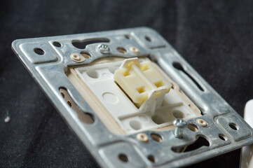 back side of electrical wall switch with visible wiring contacts and metal mounting frame, detailed...