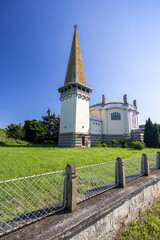 Evangelical church standing in Mula, Slovakia, featuring unique architecture and rusty fence