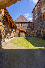 Svihov water castle courtyard showing ramparts, wooden roof and grass on sunny day in Czechia