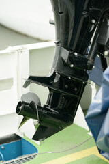 Black outboard motor lower unit with metal propeller generates efficient thrust and steering for...