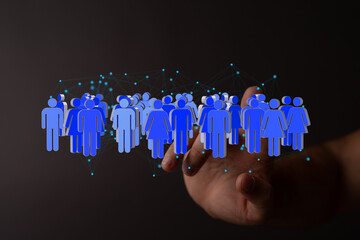 Image of a hand interacting with a digital network of people, symbolizing global connection and...