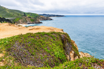 Dramatic ocean cliffs and lush coastal hills seen from Devils Bunker overlook, near Gray Whale Cove...