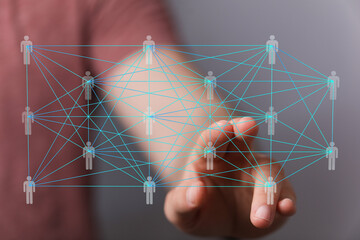 Image of a hand interacting with a digital network of interconnected people.  Represents global...
